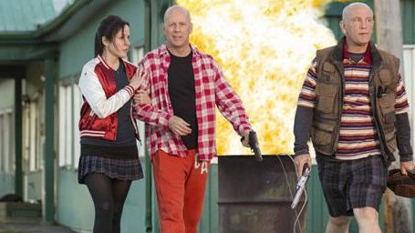 bild aus der news "R.E.D. 2": Figurenposter mit Bruce Willis und John Malkovich samt Raketenwerfer inmitten einer Schafherde