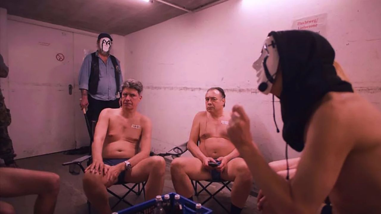 Im Muxismus werden Arbeitslose zu maskentragenden Guerilla-Polit-Propagandisten umgeschult.