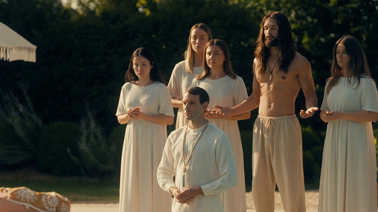 Was tut man nicht alles für die perfekte Hochzeits-Location? In „So Happy It Hurts“ treten die Gäste sogar spontan einem religiösen Kult bei …