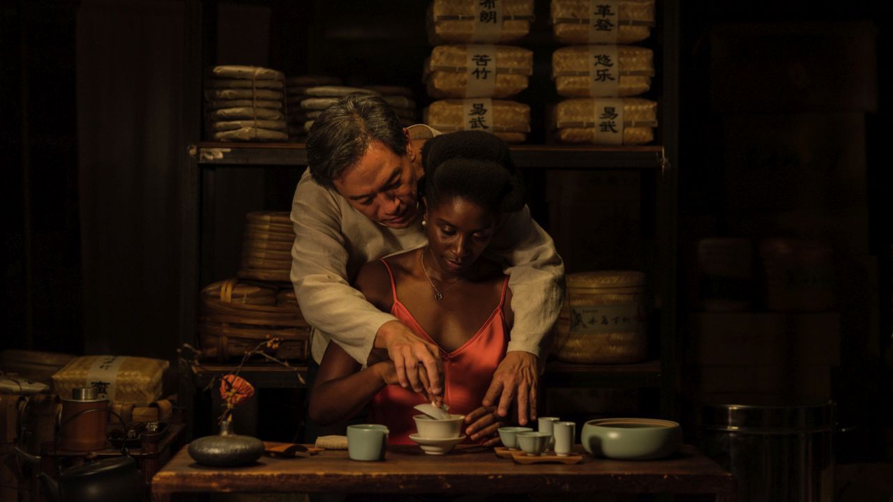 Wang (Han Chang) zeigt Aya (Nina Mélo), wie man Tee richtig einschenkt – und weckt damit Erinnerungen an eine ikonische Szene aus „Ghost – Nachricht von Sam“.